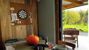 Un comedor con una mesa dispuesta para dos personas, un dardo y una calabaza sobre la mesa.
