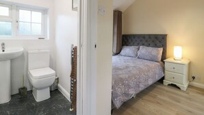A bedroom with a bed, bedside table, and a nightstand. - Headmasters Hollow (Watford)