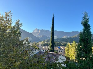A town with a prominent church tower, surrounded by mountains and trees. - A vacation rental for 2 people located in the heart of Saillans—charming and peaceful. (Saillans)