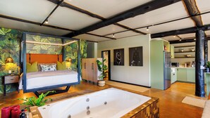 Ein modernes Schlafzimmer mit einem großen Bett, einer Badewanne und einer Wand in Grüntönen.