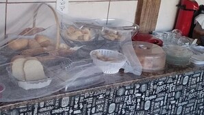 A kitchen counter with various food items and containers, including plastic cups and baskets. - Hotel Vale do Rio (Sao Goncalo do Abaete)
