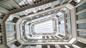 Un edificio moderno con un diseño geométrico y angular, y varios tragaluces que dejan entrar luz natural.