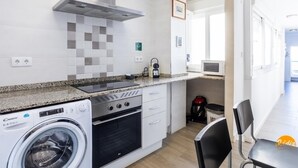 A modern kitchen with a built-in washing machine, oven, and microwave. - Atico Catedral by Cadiz Time (Cádiz)