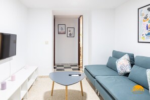 Ein modernes Wohnzimmer mit Sofa, Couchtisch, Fernseher und einer Bank.