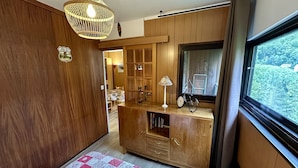 Ein gemütliches Zimmer mit Holzwänden, einem Schrank mit Schubladen, einer Lampe und einem Fahrrad.