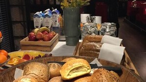 Μια ποικιλία από αρτοσκευάσματα, όπως κρουασάν και άλλα γλυκά, τοποθετημένα σε ένα ξύλινο μπολ.