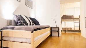 A bedroom with a wooden bed, a desk, and a bunk bed. - Casa Isabela by Cadiz Time (Cádiz)