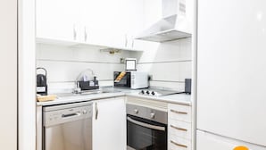 Een kleine keuken met een vaatwasser, oven en broodrooster.