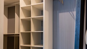 A storage unit with multiple shelves and a wooden stool. - La Luz de Cadiz by Cadiz Time (Cádiz)