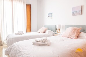 A hotel room with two beds, white bedding, and a wooden door. - Casa Capuchinos Free Parking by Cadiz Time (Cádiz)