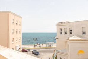 A coastal urban scene with buildings, a road, and a sea view. - Casa Capuchinos Free Parking by Cadiz Time (Cádiz)