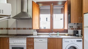 A compact kitchen with a built-in oven, dishwasher, and washing machine. - Casa Capuchinos Free Parking by Cadiz Time (Cádiz)