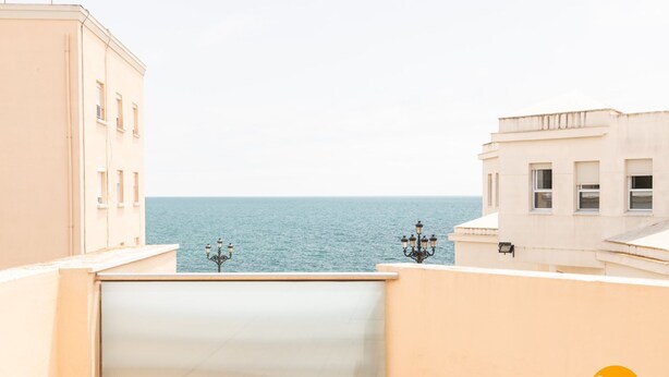 A view of a coastal building with a sea in the background. - Casa Capuchinos Free Parking by Cadiz Time (Cádiz)