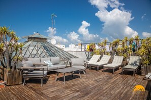 A rooftop lounge with a glass dome structure, lounge chairs, and potted plants. - La Bella Escondida by Cadiz Time (Cádiz)