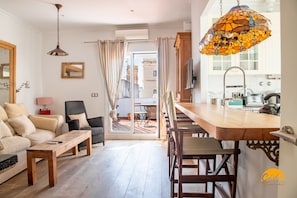 A modern living room with a sofa, a wooden coffee table, and a dining area with chairs and a table. - La Bella Escondida by Cadiz Time (Cádiz)
