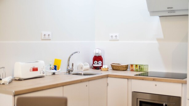 A modern kitchen with a toaster, kettle, sink, and microwave. - Tailor s Home by Cadiz Time (Cádiz)