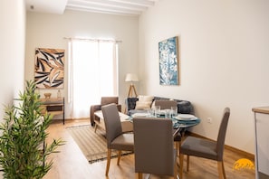 Uma área de refeições moderna com uma mesa redonda, cadeiras e um sofá.