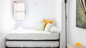 A bedroom with a bed, pillows, a nightstand, a lamp, and a painting on the wall. - Casa Rehala Nisa by Cadiz Time (Cádiz)