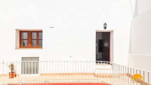 A white building with a balcony, a wooden door, and a window. - Casa Rehala Nisa by Cadiz Time (Cádiz)