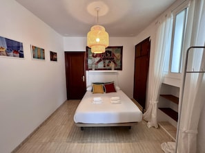 A hotel room with a bed, a hanging light fixture, a door, and a window. - La Roca del Sur by Cadiz Time (Cádiz)
