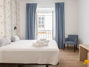 A hotel room with a bed, a chair, a desk, and a balcony with curtains. - La Luz de La Vi a Free Parking by Cadiz Time (Cádiz)