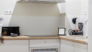Ett modernt kök med en inbyggd ugn, en kaffemaskin och en brödrost.