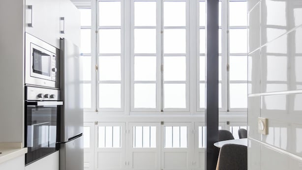 A modern kitchen with built-in appliances and large windows. - Apartamento Bike by Livework (Cádiz)
