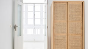 A white door with a glass panel and a wooden door with a woven pattern. - Apartamento Bike by Livework (Cádiz)