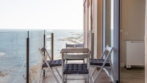 A balcony with a table and chairs overlooking a beach. - Malibu by Cadiz Time (Cádiz)