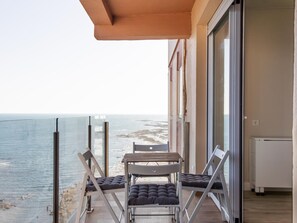 A balcony with a table and chairs overlooking a beach. - Malibu by Cadiz Time (Cádiz)