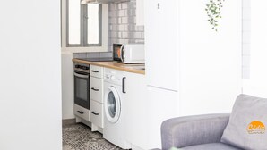 A compact kitchen with a microwave, oven, and washing machine. - Flamenco Centro by Cadiz Time (Cádiz)