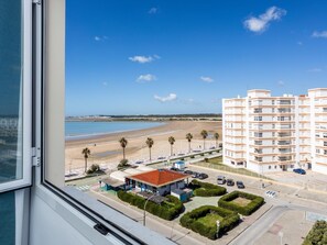 Ein Hotel an der Küste mit Blick auf den Strand, einem Parkplatz und einem Gebäude mit Balkonen.