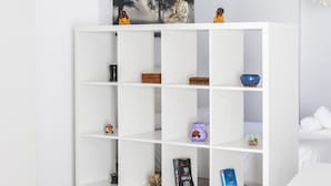 A white shelving unit with various decorative items and books. - Modern Haven Loft by Cadiz Time (Cádiz)
