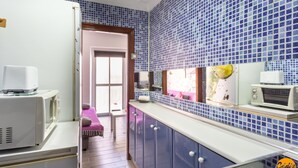 A kitchen with blue tiled backsplash, white appliances, and a view to a balcony. - Modern Haven Loft by Cadiz Time (Cádiz)