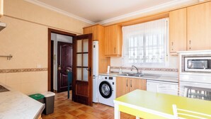 A compact kitchen with a washing machine, microwave, and wooden cabinets. - Frambuesa by Cadiz Time (Chiclana de la Frontera)