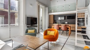 Een modern appartement met een woonkamer, eethoek en keuken.