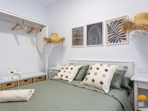 A neatly arranged bedroom with a bed, bedside tables, a wardrobe, and wall art. - Brisa de Verano by Cadiz Time (Cádiz)