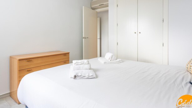 Ein Schlafzimmer mit einem Bett, einer Holzkommode und einem Kleiderschrank.