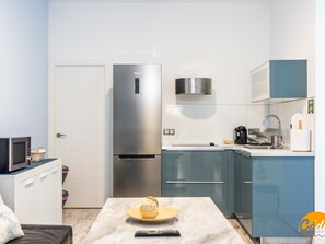 A compact kitchen with a stainless steel refrigerator, a microwave, and a sink. - Casa L a by C diz Time (Cádiz)