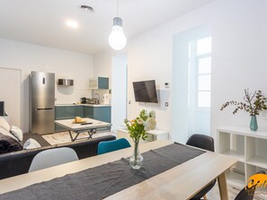 En modern lägenhet med kök, matplats och vardagsrum.