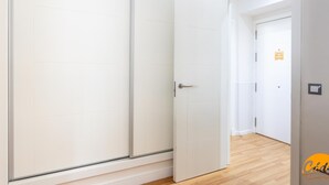 A room with a sliding door, a wooden floor, and a small sign on the wall. - Apartamento el Patio by C diz Time (Cádiz)