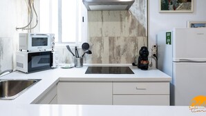 Een moderne keuken met een magnetron, koffiezetapparaat en een spoelbak.