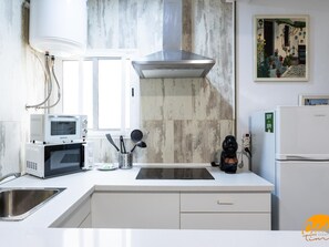 A modern kitchen with a microwave, coffee maker, and a sink. - Posada del Barrio by Livework (Cádiz)