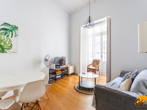 Un salon moderne comprenant un coin repas, un téléviseur et un ventilateur.