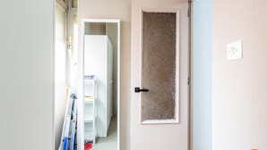 A hallway with a door leading to a room, a ladder, and a broom. - Teresa Uno by Cadiz Time (Cádiz)