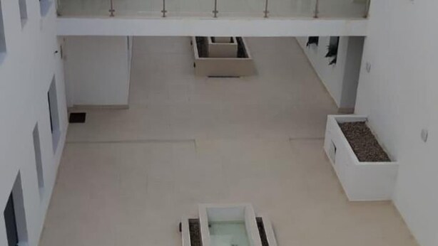 A spacious atrium with a central water feature, white walls, and a mezzanine level with railings. - Cruces by Livework in El Puerto de Santa Mar a (El Puerto de Santa Maria)