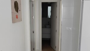 A hallway leading to a bathroom with a sink and mirror. - Cruces by Livework in El Puerto de Santa Mar a (El Puerto de Santa Maria)