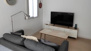 A modern living room with a sofa, a TV, a lamp, and a small table. - Cruces by Livework in El Puerto de Santa Mar a (El Puerto de Santa Maria)
