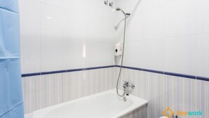 Un baño con bañera, ducha y secador de manos.