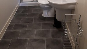 A bathroom with a glass shower enclosure, a toilet, and a sink. - Chic Studio in Cheltenham (Cheltenham)
